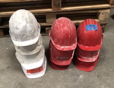 three hard hats sitting next to each other on the floor