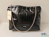 black leather handbag with chain strap and name tag on it