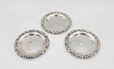 trois sous-verres en métal argenté sur fond blanc