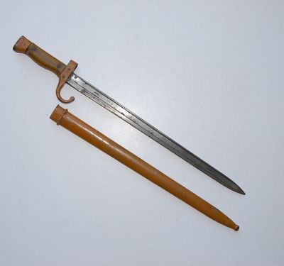 an old sword with a wooden handle sitting on top of a table
