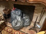 two bags of garbage sitting in front of a fire place