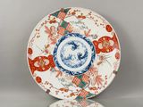 une assiette orange et bleue ornée d'un motif représentant des fleurs et des oiseaux