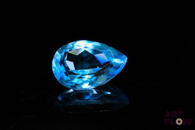 gros plan d'un diamant bleu sur une surface noire