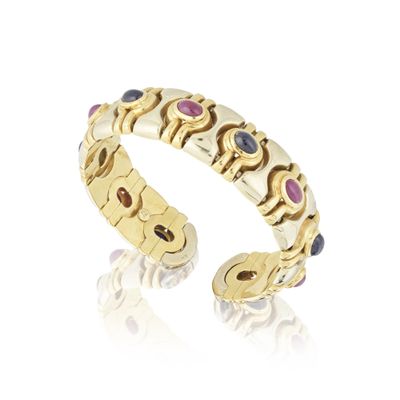 gros plan d'une bague en or avec des pierres multicolores