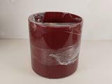 un gros plan d'un vase rouge posé sur une table blanche