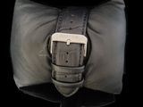 a black leather bag with a silver buckle on it