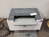 a printer sitting on top of a table next to a lamp