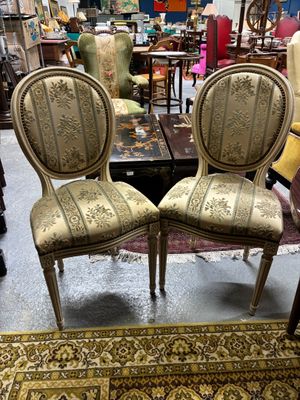 une paire de chaises anciennes dans un magasin, avec un tapis au sol
