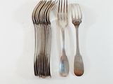 a lot of forks and spoons on a white table