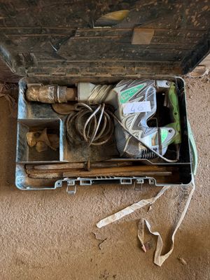 une valise posée par terre, contenant des outils