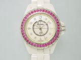 une montre blanche ornée de pierres roses sur la lunette