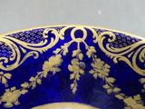 a blue bowl with gold designs on it sitting on a table