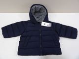 La veste est bleue et comporte une capuche qui y est intégrée.