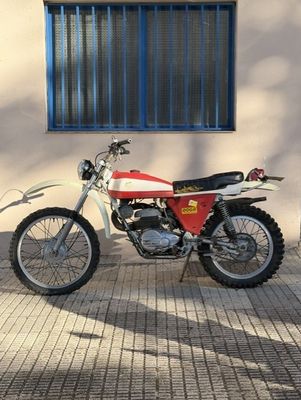 a red and white motorcycle parked in front of a building