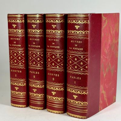 three red books sitting on top of each other on a white surface