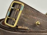 brown leather belt with brass buckle on a white background