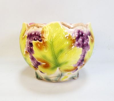 un vase jaune et violet posé sur une surface blanche