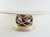 a silver cake plate with a decorative design on it