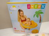 someone is holding a baby in an inflatable float in front of a box