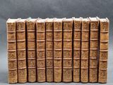 several old books stacked on top of each other on a gray surface