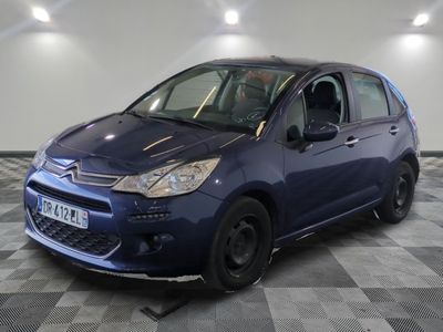 la petite voiture bleue est garée sur un sol en damier