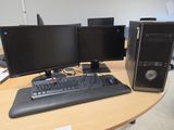 two computer monitors and a keyboard on a desk