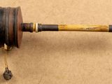an old wooden spinning wheel with a wooden handle on a brown surface