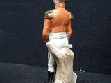 a figurine of a man in a uniform on a pedestal