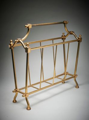 un grand porte-revues en laiton muni d'un porte-revue sur le dessus