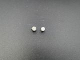 une paire de boucles d'oreilles en diamant posées sur une surface noire