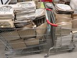 plusieurs caddies remplis de cartons et de sacs dans un magasin