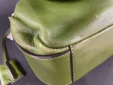 a green purse that is sitting on a table