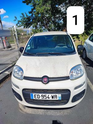une petite voiture blanche garée dans un parking