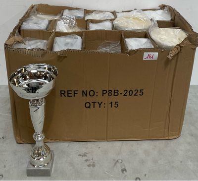 un trophée en argent posé à côté d'une boîte en carton remplie de nourriture