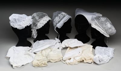 cinq mannequins noirs ornés de dentelle blanche