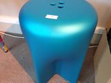 un tabouret bleu posé dans un coin de la pièce