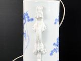 a white and blue vase with a light on it
