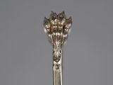 a silver spoon with a flower on it on a table