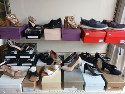 many pairs of shoes on a shelf in a room