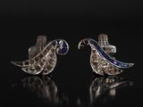 une paire de boucles d'oreilles en saphir bleu et blanc sur un fond noir