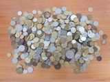 a pile of coins sitting on a wooden table