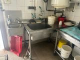 une petite cuisine équipée d'un évier, d'une cuisinière et d'autres appareils électroménagers