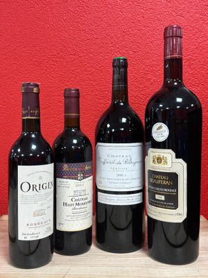 several bottles of wine are lined up on a wooden table