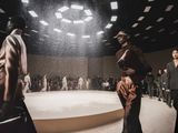 models walk down the runway at a fashion show in a dark room