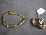 pair of gold rings and a gold bracelet on a gray surface