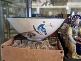 bowls and figurines are on display in a glass case