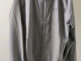 a grey jacket hanging on a hanger on a wall