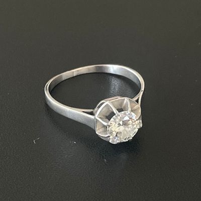 an image of a diamond ring sitting on a black surface