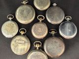six antique pocket watches are arranged in a circle on a black surface