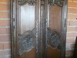 une vieille armoire en bois dans une pièce adossée à un mur de briques